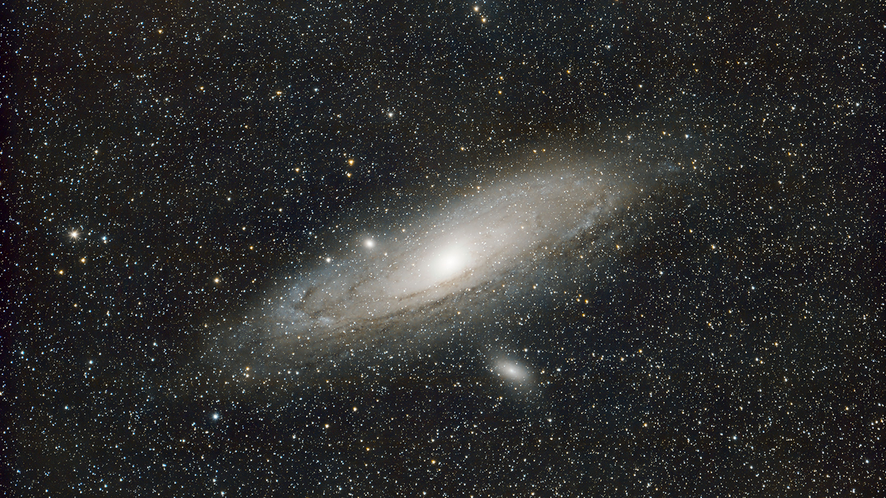 A brightly glowing spiral galaxy in deep space surrounded by thousands of distant stars.