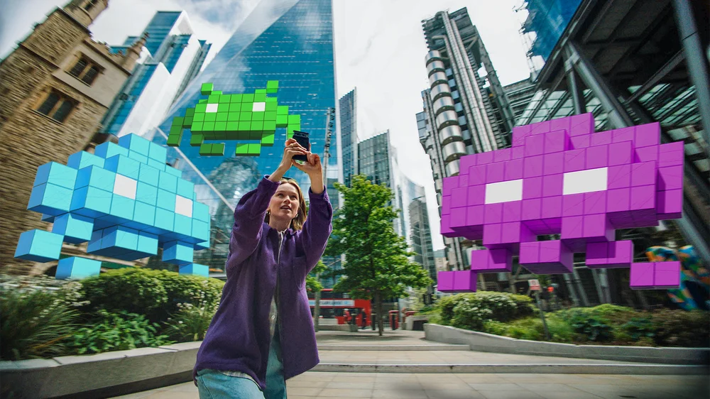 Female player defending London from 3D Space Invaders in augmented reality.