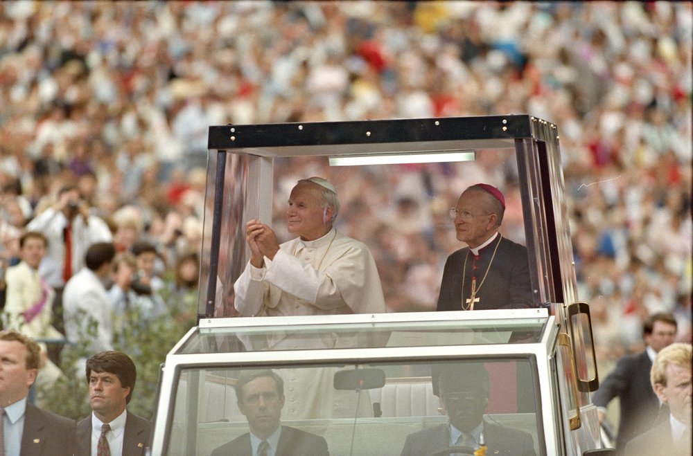 Pope John Paul II and a cardinal in the Pope Mobile inside the Silverdome in Detroit, Michigan.