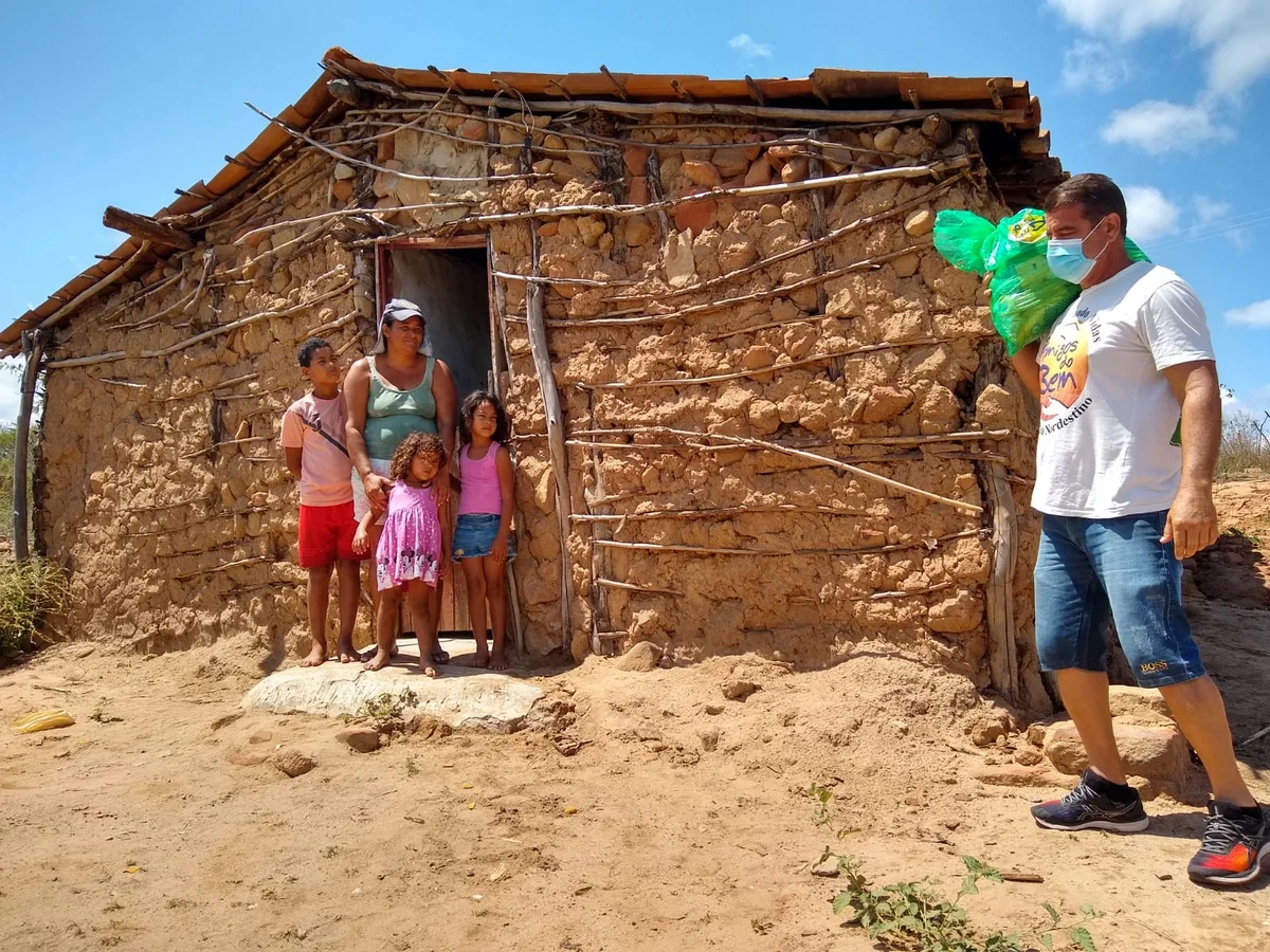 Representante da Amigos do Bem entrega cesta básica para família.