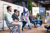 Eine Gruppe an Menschen sitzt zusammen auf einem Panel. Im Hintergrund ist der Schriftzug "YouTube Pride – damit anders sein endlich normal wird."