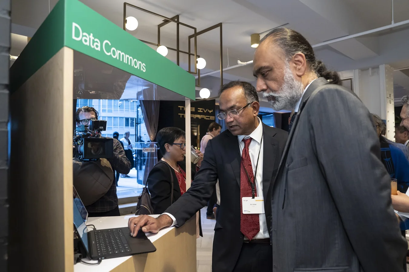 A man demonstrates an AI-driven tool on a laptop to another at a Google-hosted UNGA reception