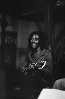 Bob Marley smiling and holding a guitar