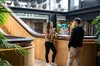 Two Googlers chat in front of an office staircase; in the background, you can see a Yoda made out of sticky notes.