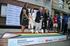 Four people hold shovels in front of a Pride flag and Google and YouTube logos.