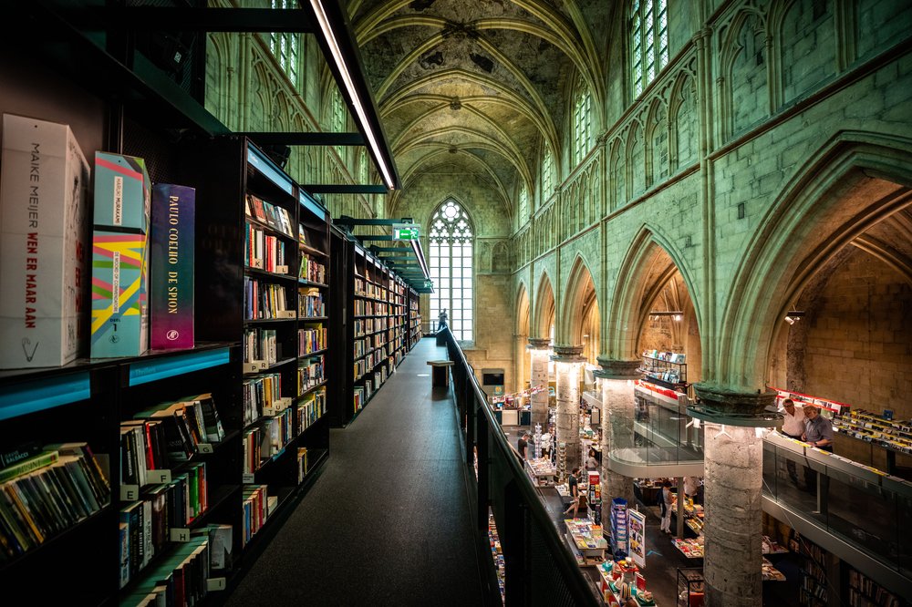 A picture of the bookshelves and beautiful arches inside of the Bookstore Dominicanen