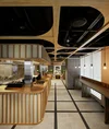 Una barra de ramen en la oficina Tokyo Stream de Google. Hay un mostrador con listones de madera para comer de pie.
