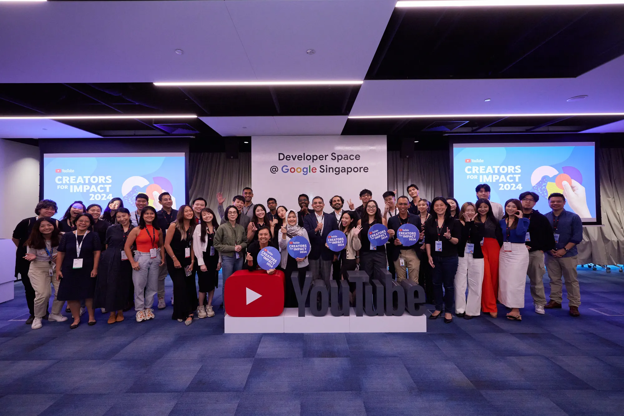 A large group of people in a room standing and looking at the camera. The background behind them reads "Developer Space @ Google Singapore"