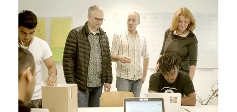 Foto auf dem mehrere Personen zu sehen sind, die auf Chromebook-Laptops schauen.