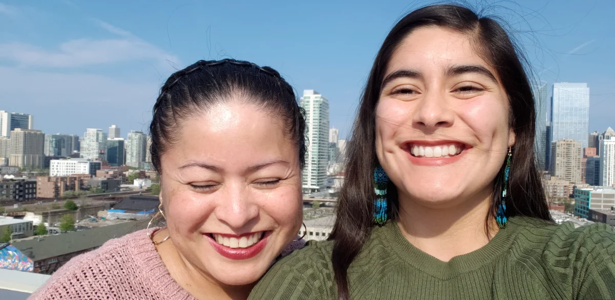 Xiomara and her mom posing on a rooftop outside.