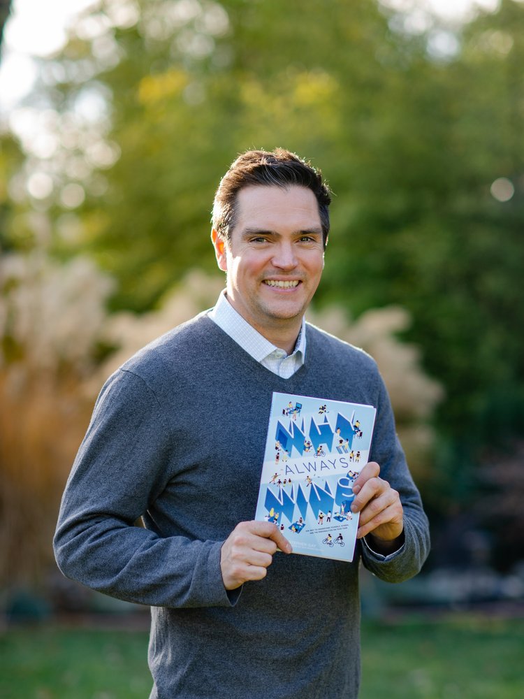 Headshot of Stephen Gay holding his graphic novel, "Why Always Wins."