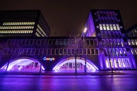 Gebäudefront des Google-Büros in München, das lila erstrahlt ist, um #PurpleLightUp zu feiern