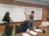 A team of researchers and scientists working together on a problem written on a whiteboard