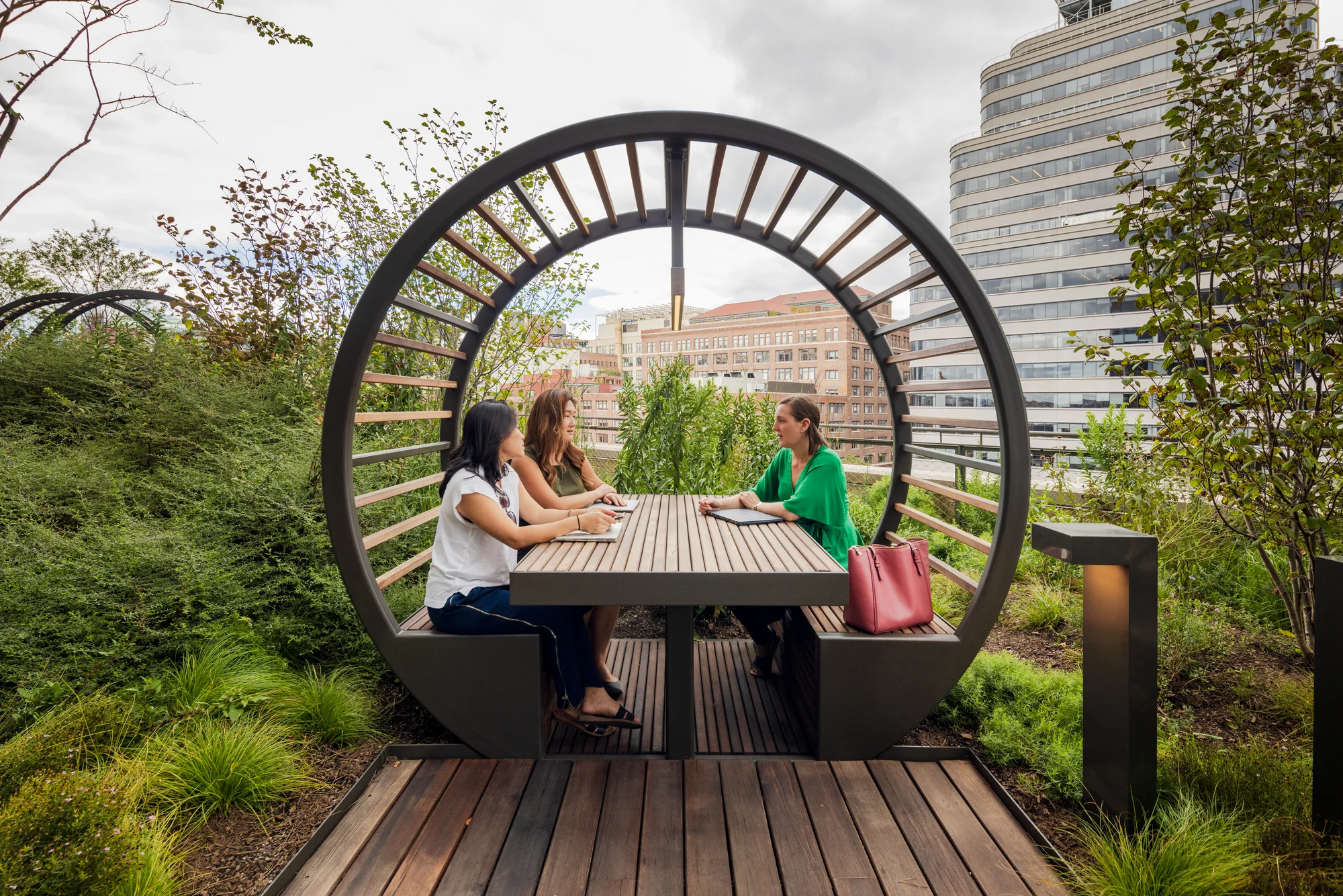 Three Googlers sit at an outdoor picnic table on the St. John's Terminal terraces.