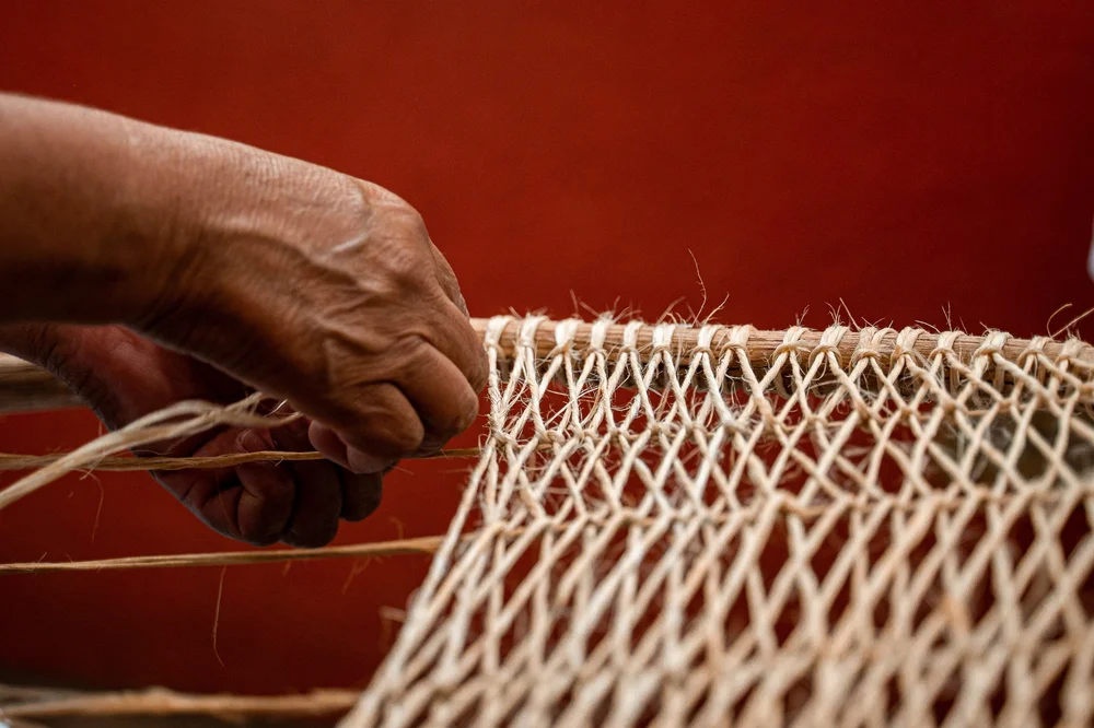 image of two hands weaving fabric