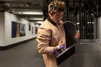 A man uses his Google Pixel Watch to pay at a train turnstile.