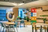 A view of a room inside the Developer Space @ Google Singapore. There are three small tables, each with four chairs, stationed around the room.