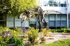 A photo of Stan, the bronze-cast replica Tyrannosaurus rex fossil mount that sits among landscaping on our Mountain View campus.