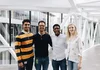 Four people posing indoors.