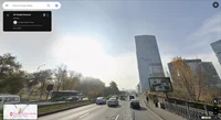 A busy city road with tall office buildings and a big blue sky