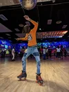 Photograph of a man roller skating in a rink.