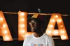 Goodman in Noogler hat and Google shirt in front of large light-up letters.