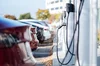 A row of electric vehicles, parked and charging.