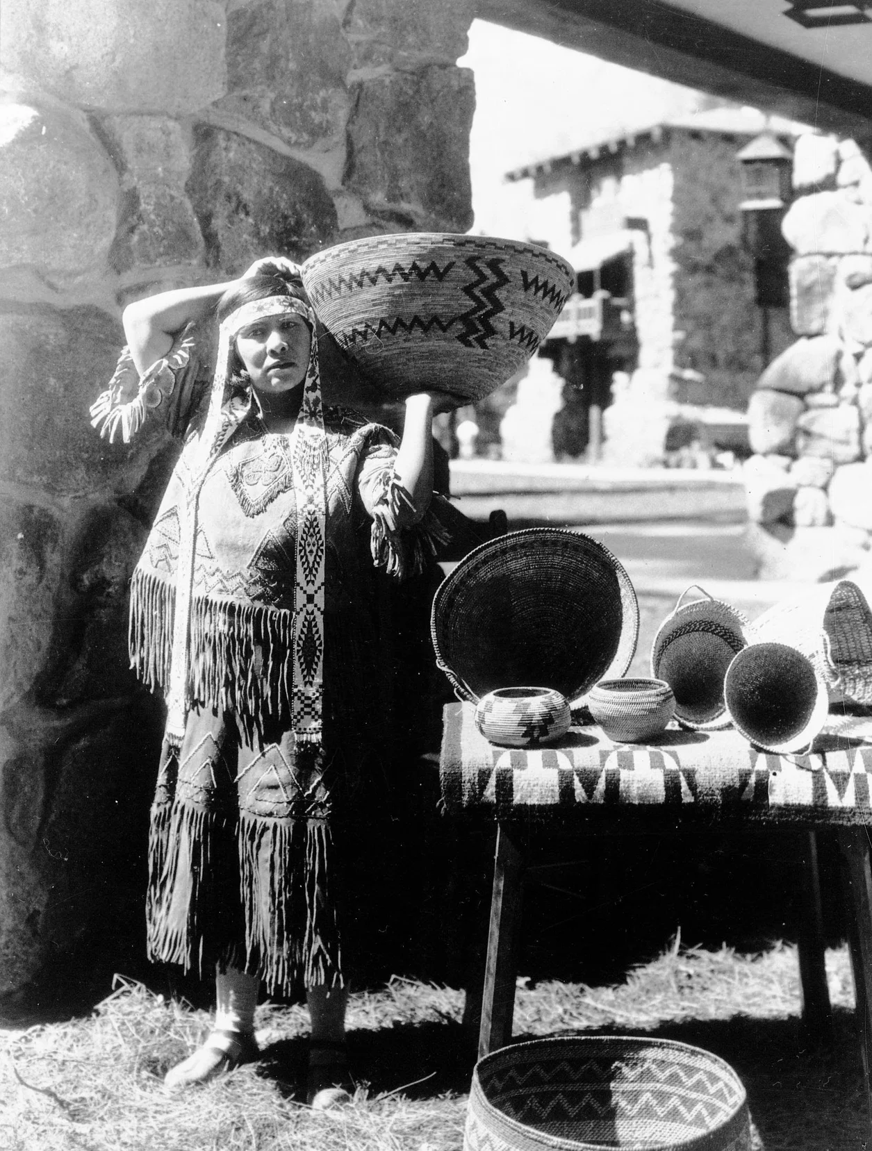 A black and white photograph of a person with baskets.