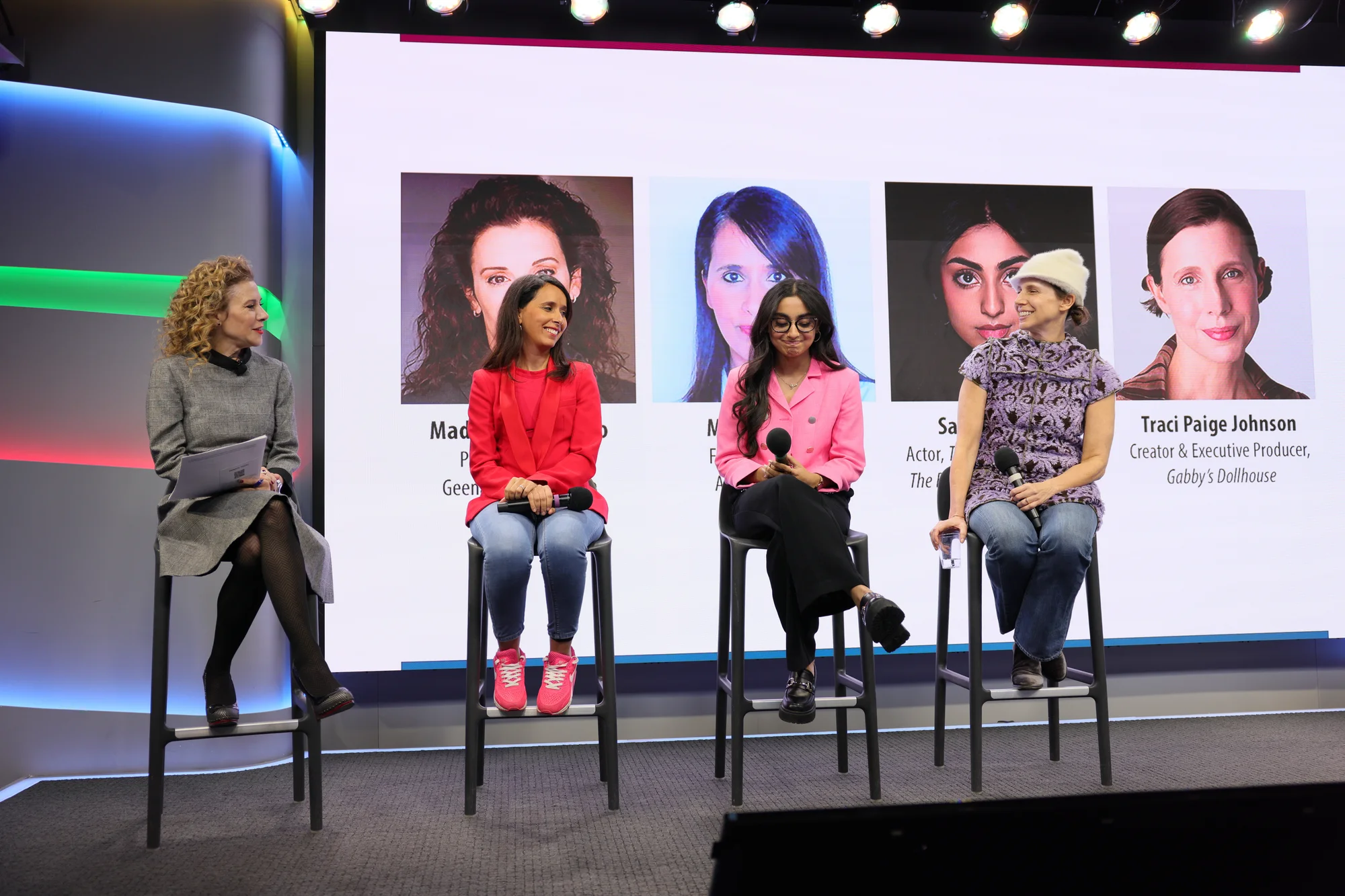 4 people sitting on high chairs, beside each other in a fireside chat panel format.