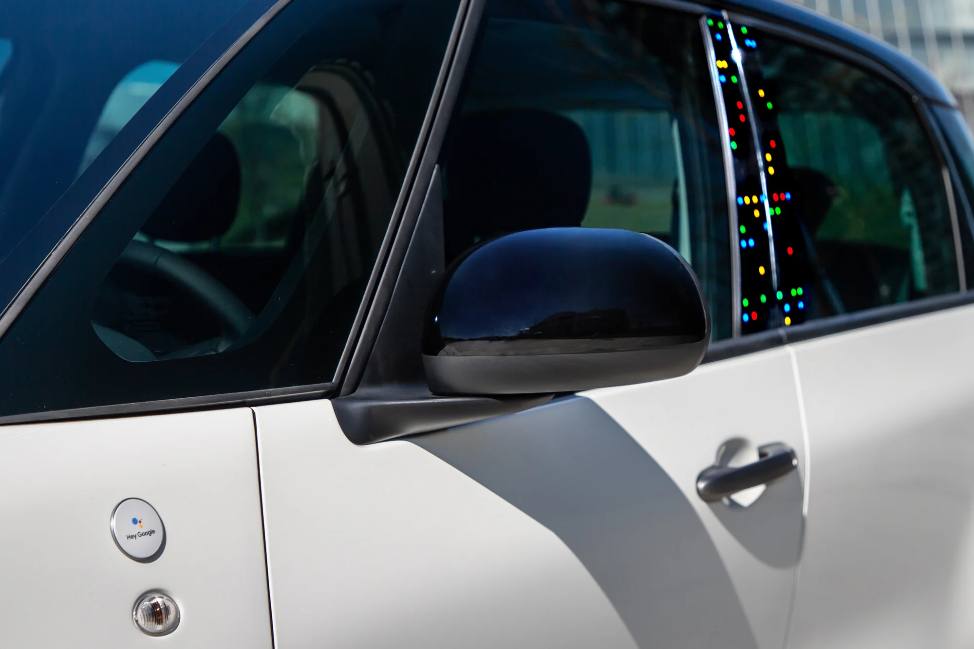 A close-up of the driver side door of the Fiat 500 showing the "hey Google" branding.