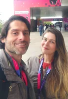 Two people pose for a selfie outside an event space.