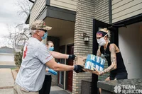 A volunteer hands a package to a Colorado resident.