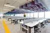 A view of an office floor in our Seoul, Korea building. There are rows of desks with ample space between them, and a wide path alongside the desks that can accommodate wheelchairs.