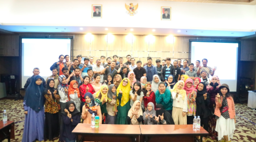 A group photo of around 50 female and male attendees from Indonesia in a hotel ballroom, after completing the free digital training workshop.