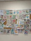 A picture of drawings made by newly arrived Afghan children on a bulletin board.