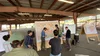 A group of seven people are standing and gathered around a local map in the U.S. Forest Service Fire Science Lab.