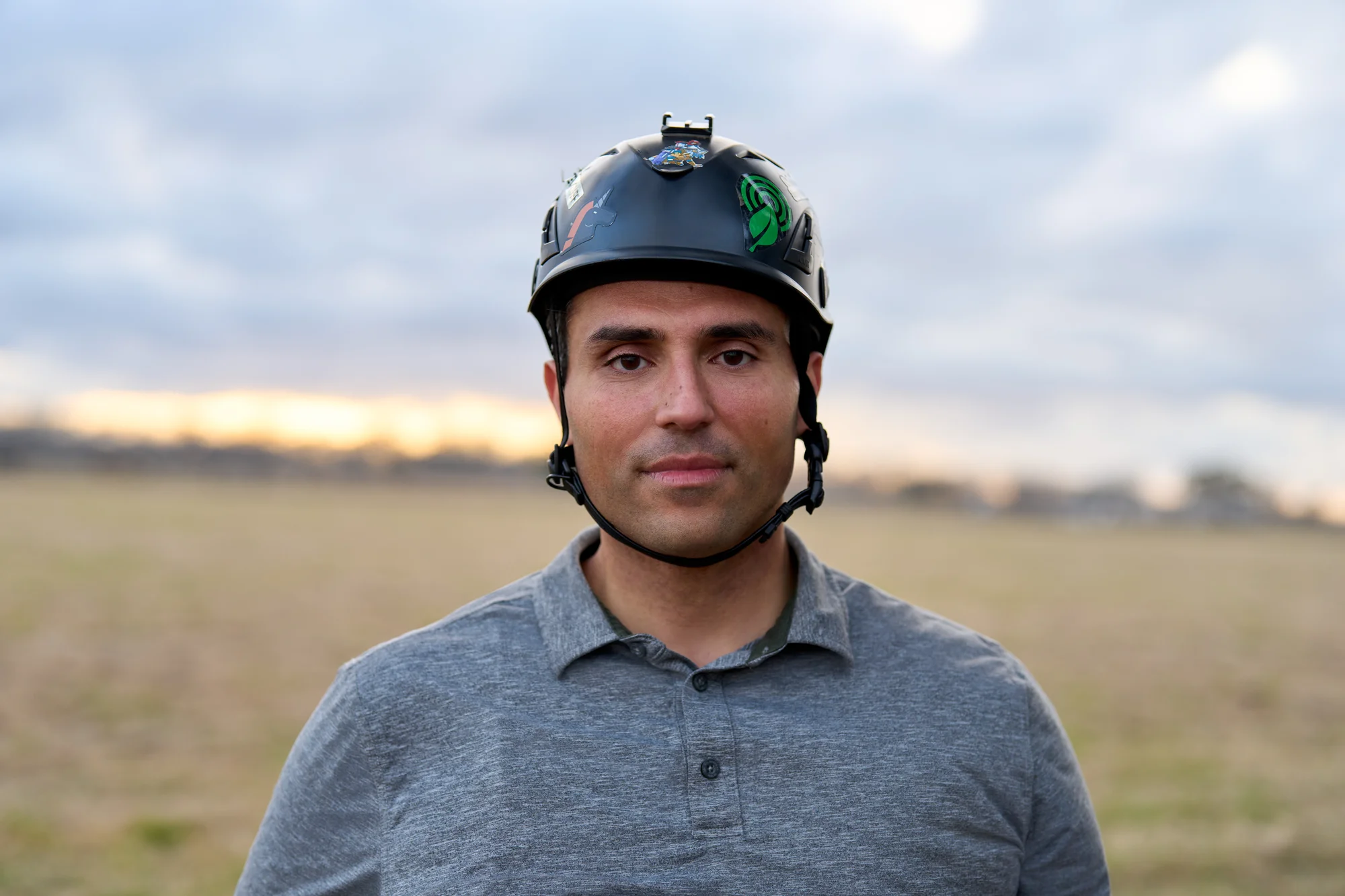 Headshot of Bourhan standing in a field and wearing a helmet.