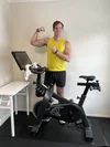 SoulCycle instructor Brent, based in Chicago, flexes his muscles next to an at-home bike.