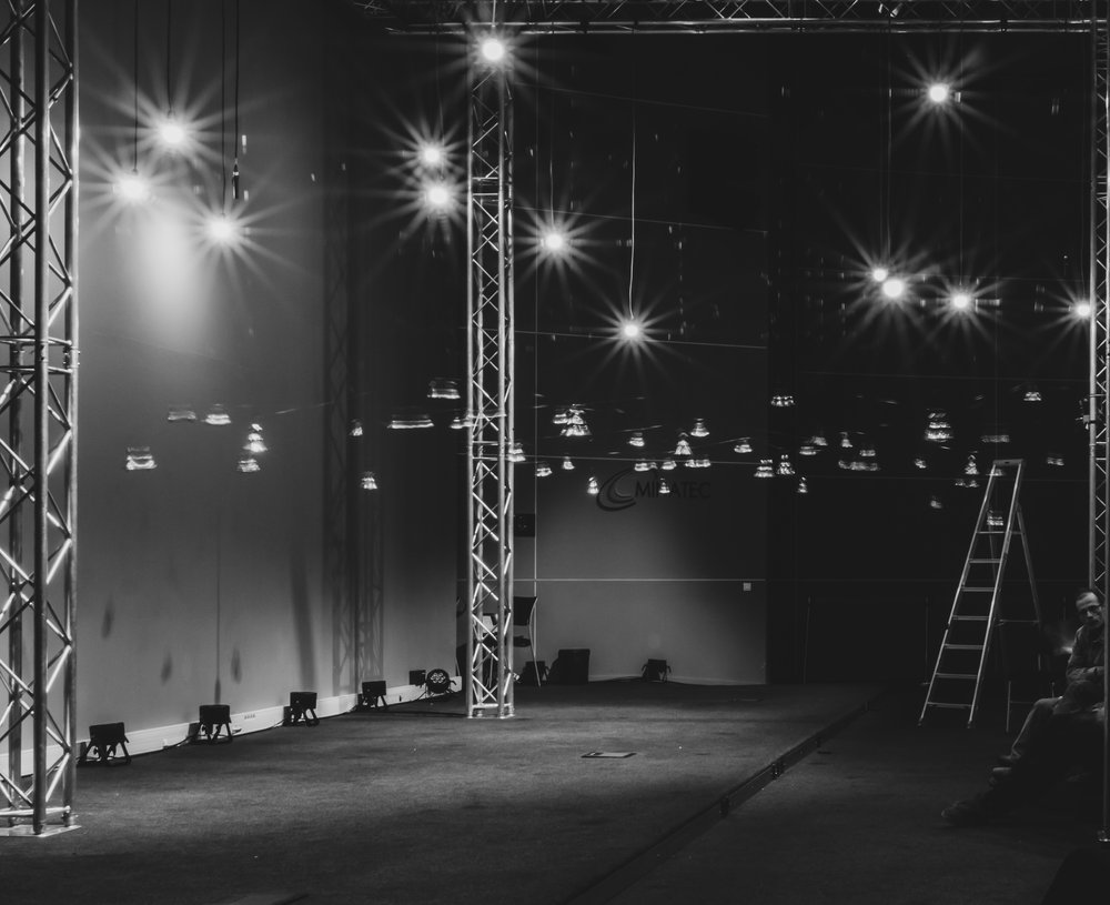 An empty stage with bells hanging on wires