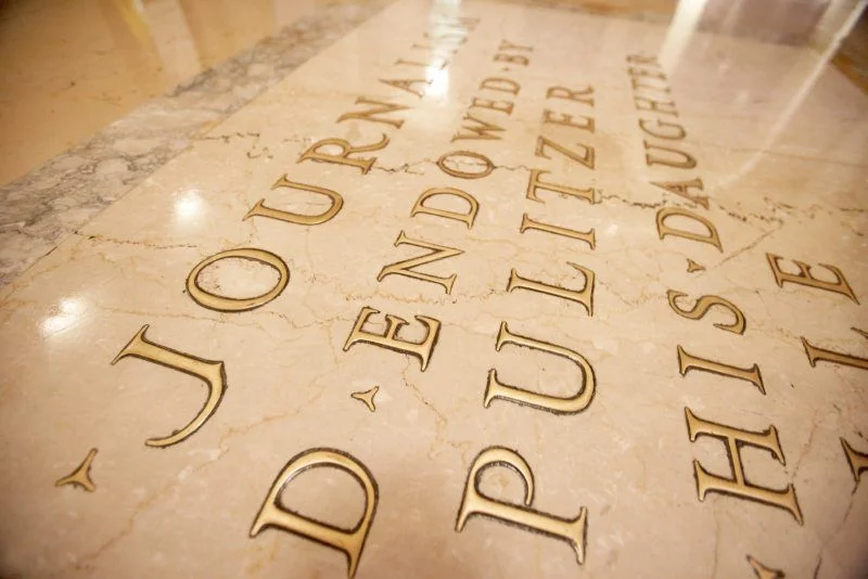 The floor of the Columbia Journalism School with engraved gold lettering