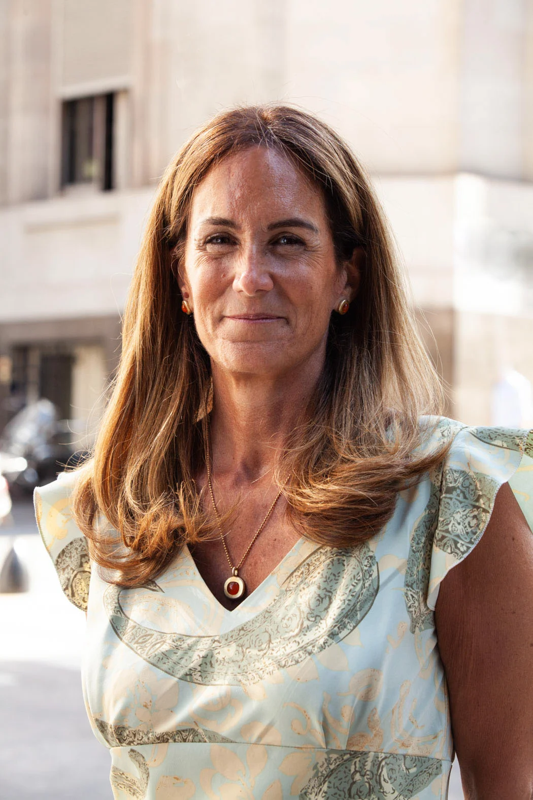 Headshot of Carmen standing in front of a building on a sunny day.