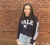 Cindy Hernandez wearing a Yale t-shirt standing in front of a brick wall