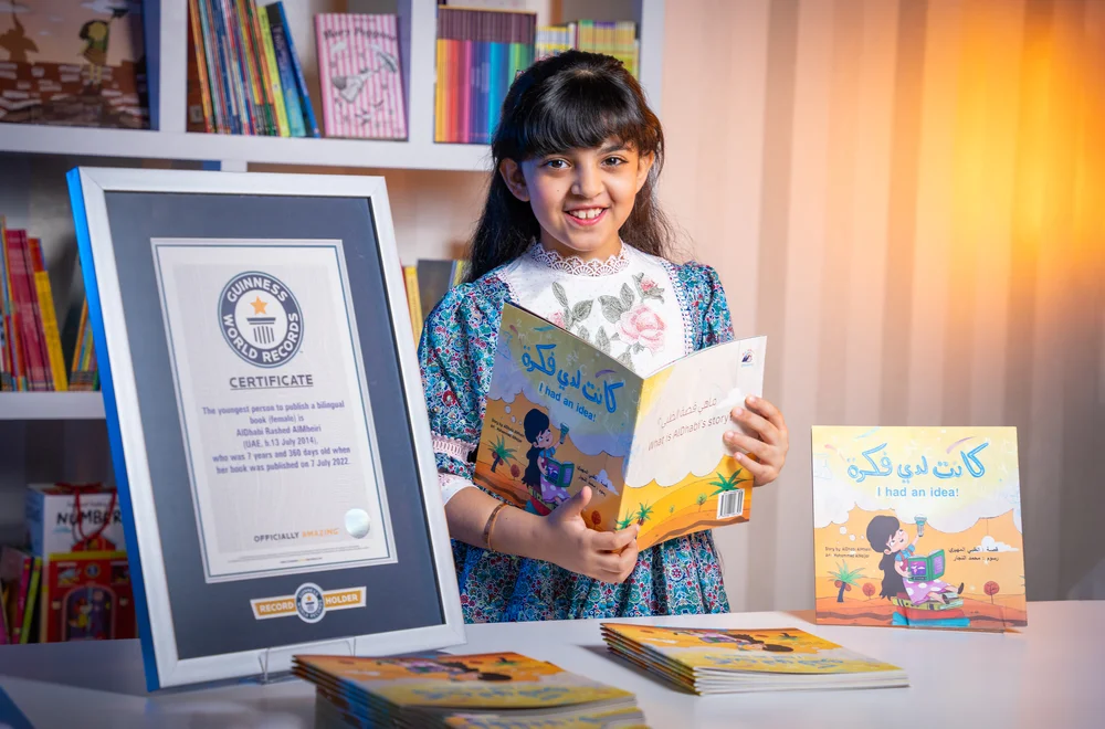 صورة لطفلة بجانبها عدد من الكتب