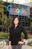 A woman standing outside a Google office building, smiling at the camera.