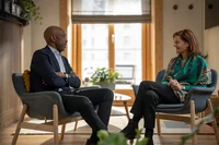 Two people seated in chairs having a conversation