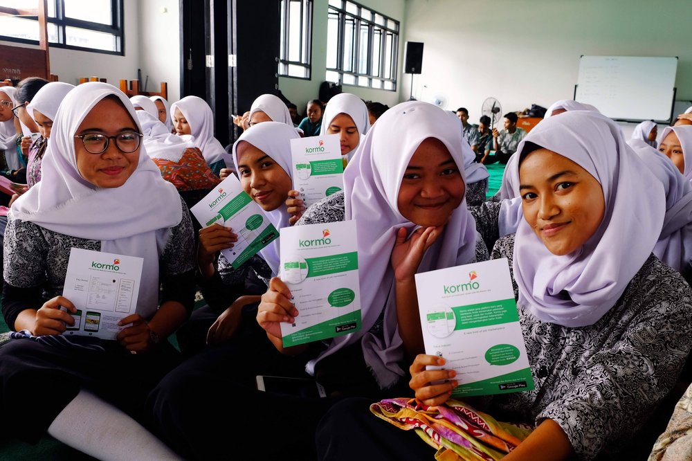 Students holding up pamphlets about Kormo