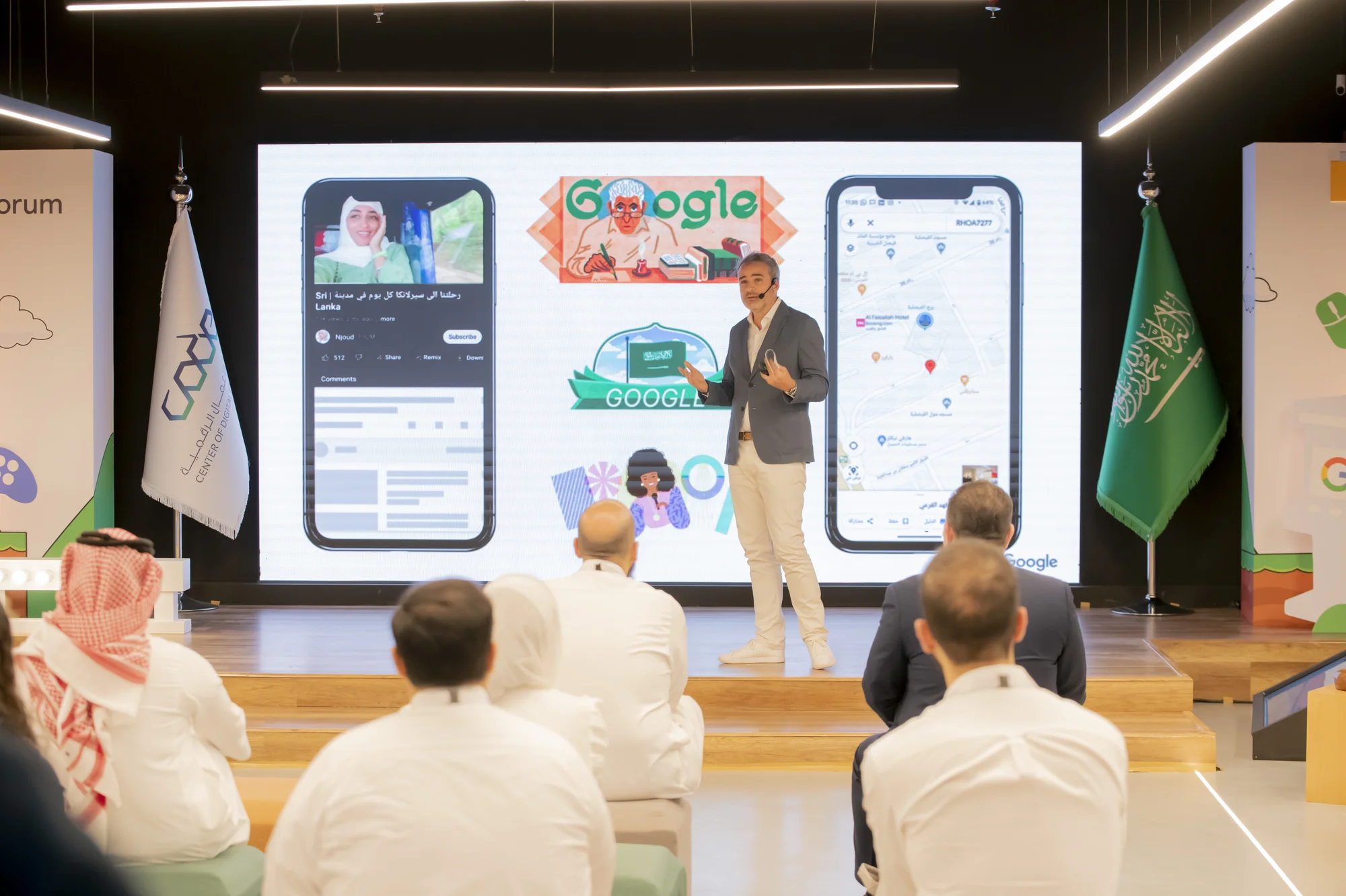 Google's Managing Director, Anthony Nakache, wearing a blue suit jacket, off-white trousers - presenting on stage to the audience