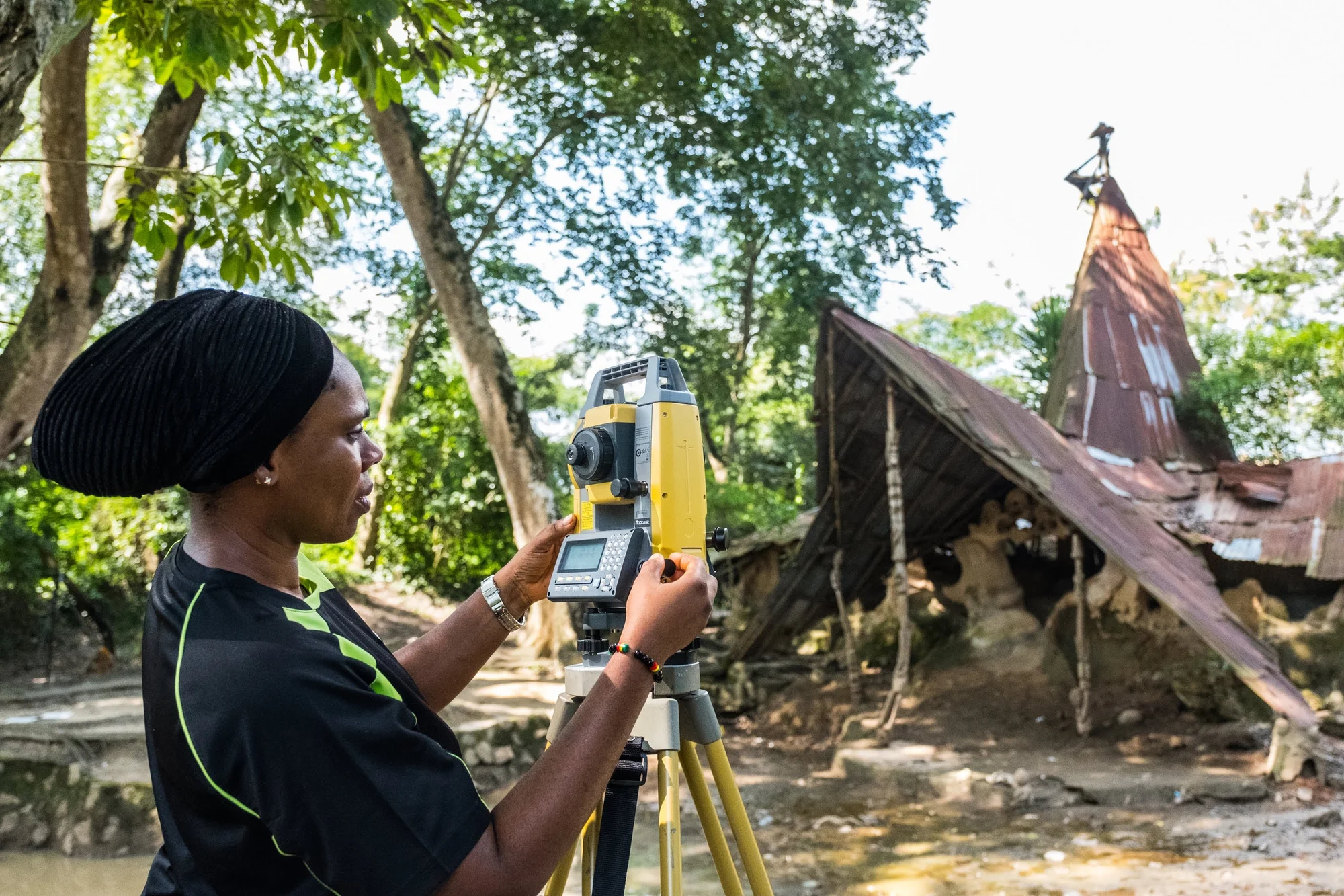 Image showing a woman, Dr. Ijeoma, adjusting the total station at Busanyin shrine c. CyArk