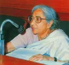 Image of Dr. Asima Chatterjee speaking into a microphone