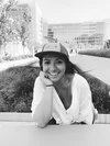 Black and white photo of a woman smiling with a Noogler hat